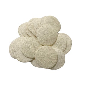 May include: A pile of round, off-white loofah sponges. The sponges are made of natural fibers and are perfect for exfoliating skin.