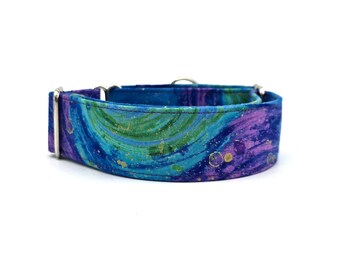 May include: A vibrant dog collar with a swirling pattern in shades of blue, teal, and purple, accented with gold flecks. The collar features a silver metal buckle and hardware, and is designed for a comfortable fit.
