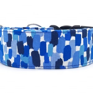 Puede incluir: Un collar para perro azul y blanco con un patr&oacute;n de pinceladas. El collar est&aacute; hecho de tela resistente y tiene una hebilla negra.