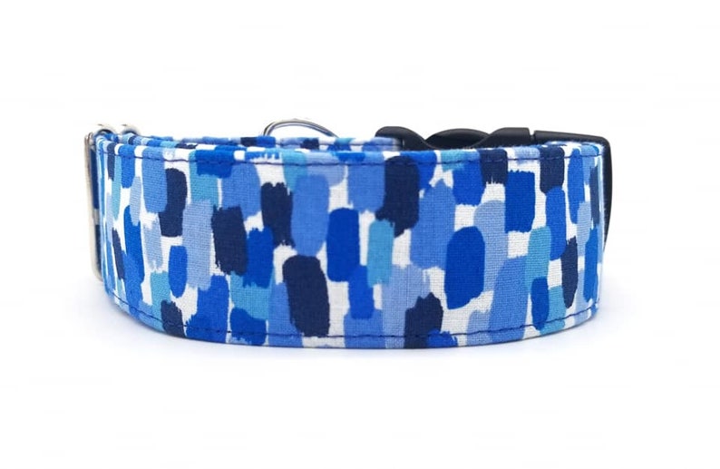 Puede incluir: Un collar para perro azul y blanco con un patr&oacute;n de pinceladas. El collar est&aacute; hecho de tela resistente y tiene una hebilla negra.