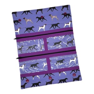 May include: Purple zippered pouch with clear vinyl pockets and a repeating pattern of black and brown dogs on a light purple background.