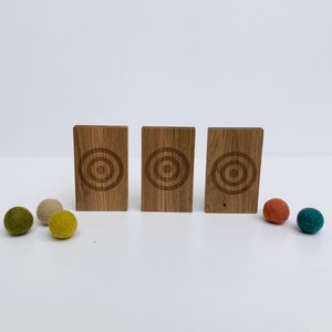 Wool Mob's Wood Slingshot Targets are handmade from sustainably harvested Maple wood and laser engraved with a three ringed target image. Shown is the dark Maple wood slingshot targets.