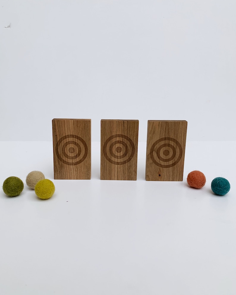 Wool Mob's Wood Slingshot Targets are handmade from sustainably harvested Maple wood and laser engraved with a three ringed target image. Shown is the dark Maple wood slingshot targets.