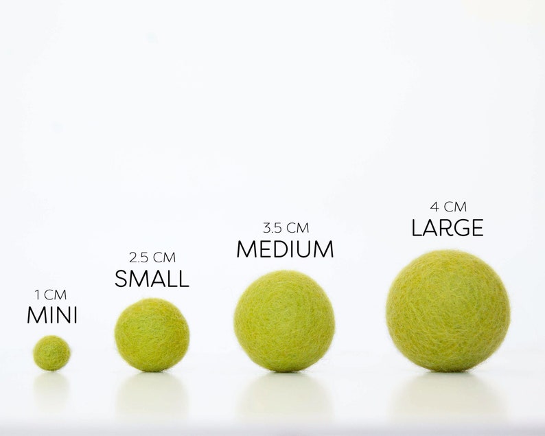 Comparison of Wool Mob's Mini, Small, Medium, and Large felt balls to one another. The color shown is Glow or a bright green.