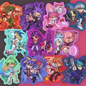 Puede incluir: Una colección de once pegatinas de estilo anime que muestran varias figuras en poses dinámicas, cada una rodeada por un borde de color distinto. Los diseños incluyen diversos colores de cabello, atuendos y motivos de criaturas acompañantes.