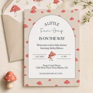 Könnte beinhalten: Eine beige Babyparty-Einladungskarte mit passendem Umschlag, verziert mit einem Muster aus roten und weißen Pilzen. Die Karte hat einen bogenförmigen Rahmen mit dem Text A LITTLE Fun-Guy IS ON THE WAY sowie den Veranstaltungsdetails.