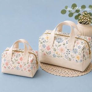 May include: Two rectangular zippered bags with top handles, featuring a floral pattern of pink, blue, and yellow flowers on a white background with solid cream-colored bases. The text MyLittleSewingMonkey is visible in the upper right corner.