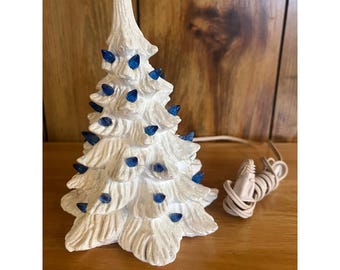 Vintage witte keramische kerstboom met blauwe lichten Feestdagendecoratie op tafel