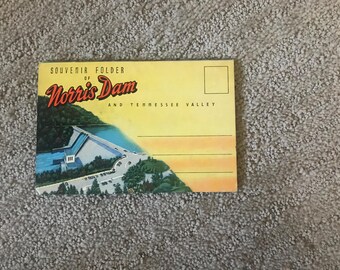 May include: Vintage souvenir postcard of Norris Dam and Tennessee Valley. The postcard features a colorful illustration of the dam, with text that reads "Souvenir Folder of Norris Dam and Tennessee Valley". The postcard has a yellow background.