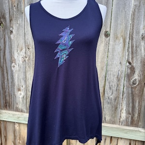 May include: A navy blue tank top with a stylized lightning bolt design in shades of blue and purple. The sleeveless top has a scoop neckline and a slightly asymmetrical hemline. The lightning bolt is centered on the chest.