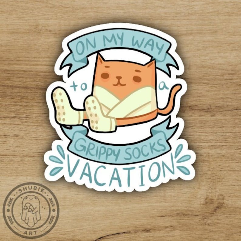 May include: A sticker featuring a cartoon cat wearing a white robe and blue socks with the text "On my way to a grippy socks vacation".