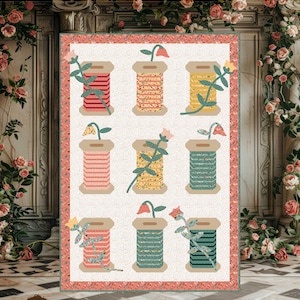 Puede incluir: Un patrón de edredón llamado "Garden Spools" con nueve carretes de hilo de varios colores, cada uno adornado con detalles florales. El tamaño final es de 153,7 cm x 221 cm. El patrón es de Jennifer Long.