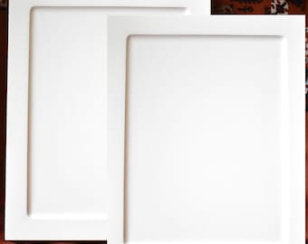 May include: Two white picture frames with a simple, modern design. The frames are made of a thick, sturdy material and have a smooth, matte finish.