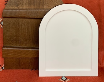 May include: Two arched wooden frames, one brown and one white, are displayed against a red patterned background. The frames are both approximately 12 inches tall and 10 inches wide.
