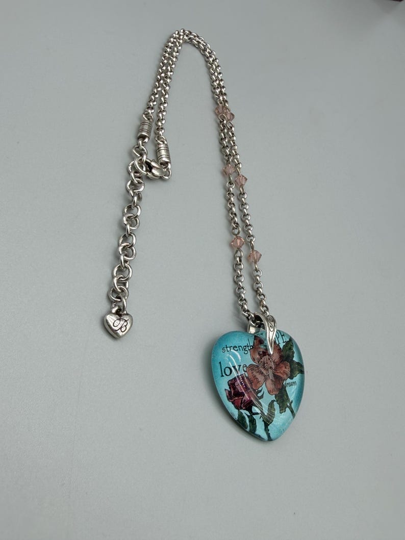 May include: A white ceramic mug with a black handle and the text "But First, Coffee" in a bold, black font. The mug is set against a blurred background, suggesting a cozy setting. The mug appears to be approximately 4 inches tall.