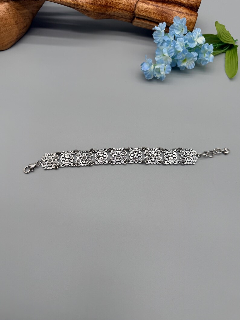 以下が含まれることがあります： 黒いハンドルと「But First, Coffee」のテキストが黒い太字で書かれた白いセラミックマグ。マグは白い表面に置かれています。