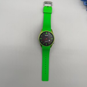 May include: A wristwatch with a bright green silicone strap and a matching green bezel. The round watch face is black with green hour markers, a red second hand, and the brand name IZOD printed in white at the top center of the dial.