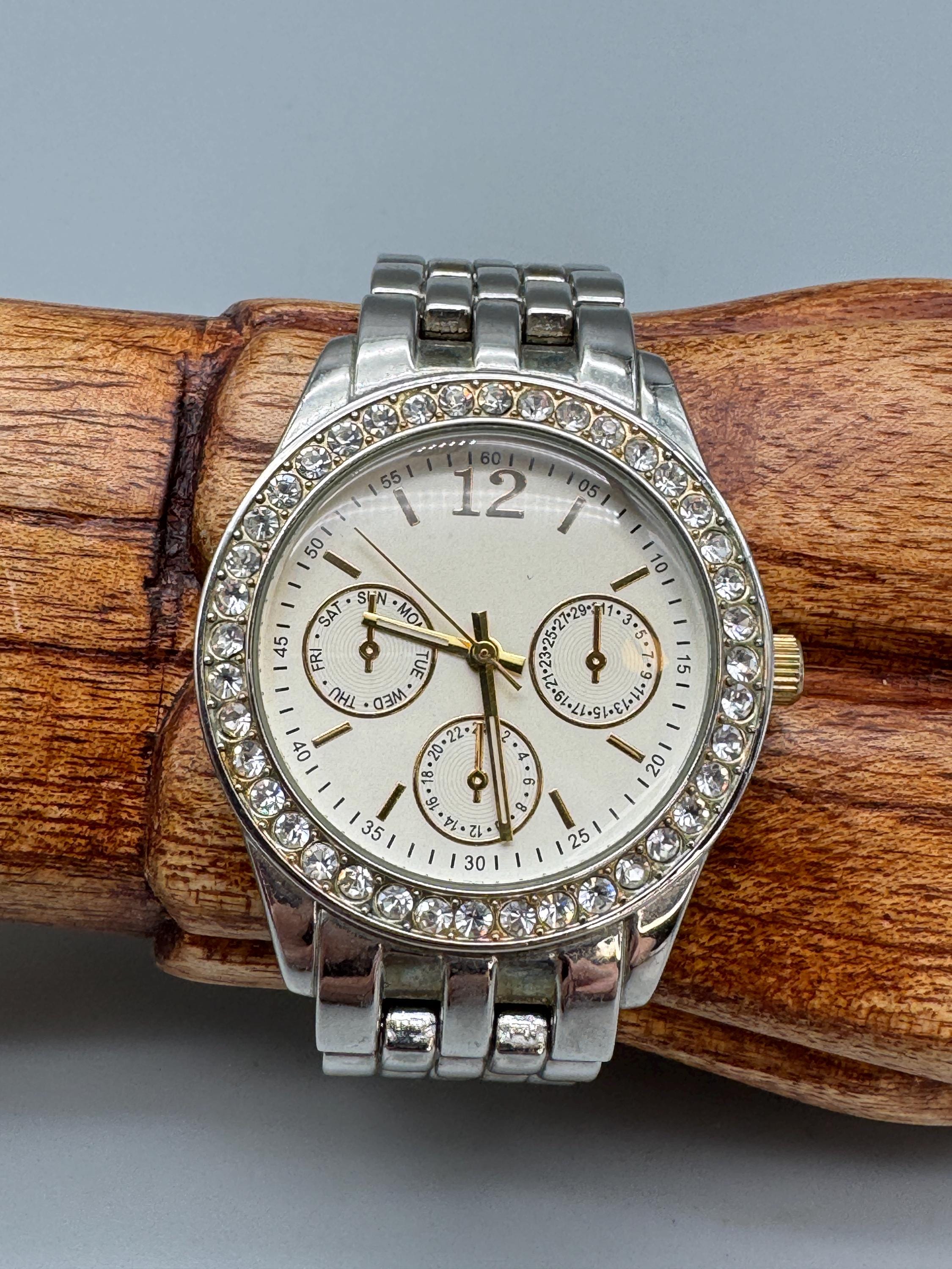 クリスタルベゼルとゴールドトーンのアクセントが付いたシルバーの