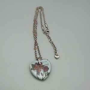 May include: A set of three ceramic mugs with a speckled, cream-colored glaze. Each mug features a different hand-painted floral design in shades of blue, green, and yellow. The mugs have a simple, rounded shape and a comfortable handle.