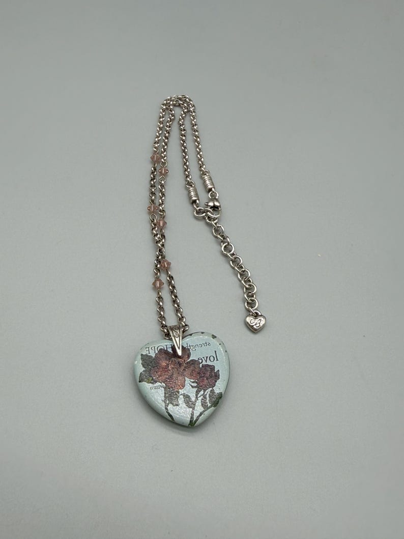 May include: A set of three ceramic mugs with a speckled, cream-colored glaze. Each mug features a different hand-painted floral design in shades of blue, green, and yellow. The mugs have a simple, rounded shape and a comfortable handle.