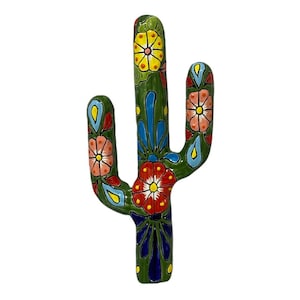 May include: A ceramic cactus sculpture with a vibrant design. The green cactus features colorful floral patterns in red, yellow, blue, and pink. The decorative piece is likely for home decor.