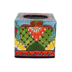 May include: Square ceramic tissue box cover with a colorful floral design. The design features red, orange, yellow, green, and blue flowers and leaves on a light blue background.