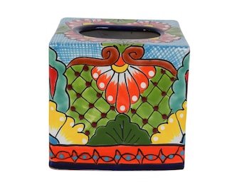 May include: Square ceramic tissue box cover with a colorful floral design. The design features red, orange, yellow, green, and blue flowers and leaves on a light blue background.