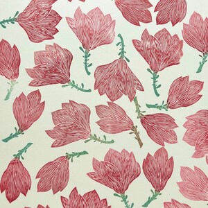 May include: A white background with a repeating pattern of pink magnolia flowers. The flowers are stylized and have a hand-drawn look.
