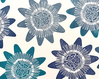 May include: A white background with a repeating pattern of blue and teal passionflower blossoms. The flowers are stylized and have a detailed center with a white outline.