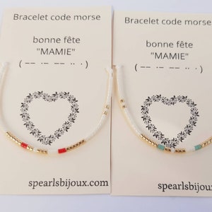 Peut inclure: Deux bracelets en code Morse sur des cartes. Les cartes indiquent "Bonne Fête MAMIE" et présentent un motif de cœur. Un bracelet a des perles rouges et dorées, l'autre a des perles turquoise et dorées. Le site spearlsbijoux.com est visible.