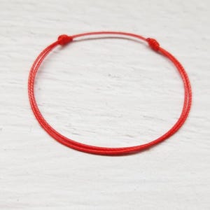 Minimalistisches rotes Armband aus dünner Polyesterschnur mit Schiebeknoten