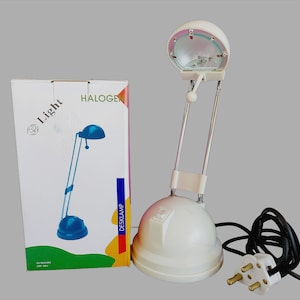 May include: A white halogen desk lamp with a blue base and a long, adjustable arm. The lamp has a round, white shade with a clear glass lens. The lamp is plugged into a three-pronged electrical outlet. The lamp is packaged in a white box with the words "Light" and "Halogen" printed on it.