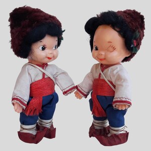 two dolls of a boy and a girl holding hands