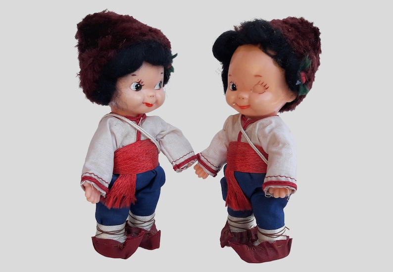 two dolls of a boy and a girl holding hands