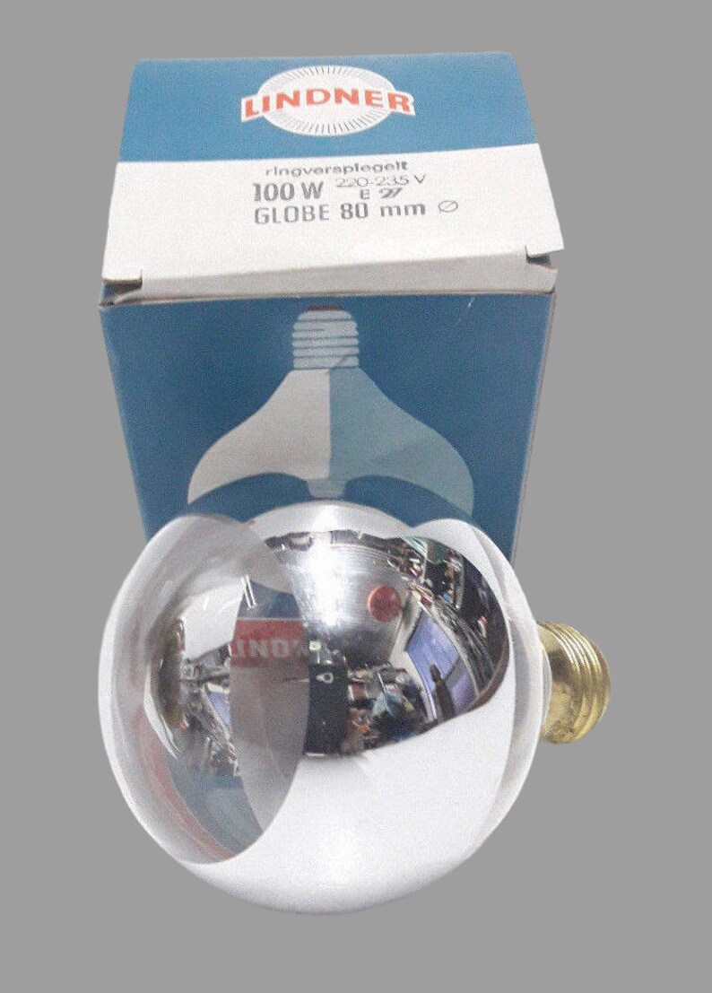 May include: A silver globe light bulb with a clear glass base. The bulb is in its original packaging, which is blue and white and says "Lindner ringverspiegelt 220-230V 100W E27 GLOBE 80 mm".