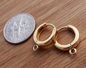 以下が含まれることがあります： ヒンジ留めの金色のフープイヤリングのペア。イヤリングはアメリカの10セント硬貨と同じくらいの大きさです。