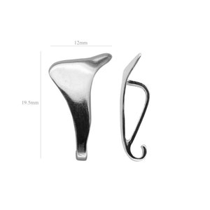 Puede incluir: Dos hallazgos de joyería de metal plateado, uno con forma de gancho curvo y el otro con forma de lágrima. El gancho mide 12 mm de largo y la lágrima 19,5 mm de largo.