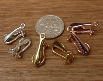 Pode incluir: Quatro fechos de clip para brincos em ouro, prata e ouro rosa. Os fechos são mostrados ao lado de uma moeda de 10 cêntimos para comparação de tamanho.