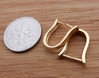 May include: A pair of gold hoop earrings with a simple, curved design. The earrings are shown next to a US dime for scale.