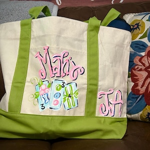 May include: A cream-colored canvas tote bag with lime green straps and a lime green base. The front features hand-painted pink lettering that reads "Mahj" and "JA" alongside a graphic of three mahjong tiles with the numbers 3, 4, and 5.