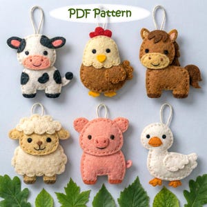 Può includere: Ornamenti fatti a mano a forma di animali della fattoria in feltro: mucca, gallina, cavallo, pecora, maiale e anatra. Ogni ornamento presenta dettagli cuciti e un anello per appenderlo. Il testo "PDF Pattern" è visibile.