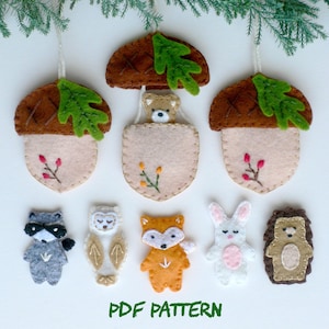 Può includere: Un modello PDF per ornamenti di animali del bosco in feltro. Il modello include un orso, una volpe, un gufo, un procione, un coniglio e un riccio. Il modello include anche due ornamenti a forma di ghianda con una foglia e delle bacche.