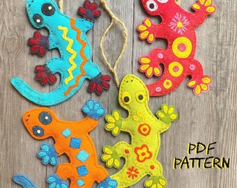 May include: Four colorful felt lizard ornaments with string hangers. The lizards are in shades of blue, orange, red, and green, with decorative patterns and details. The text "PDF PATTERN" is visible in the image.