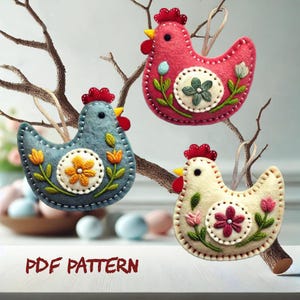 May include: Three felt chicken ornaments with embroidered flowers and a circle in the centre. The chickens are red, blue, and white. The text "PDF PATTERN" is at the bottom of the image.