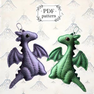 May include: PDF pattern for two felt dragon ornaments. One dragon is purple and the other is green. Both dragons have stitched details and are ready to be sewn.