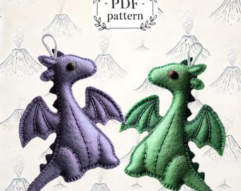 May include: PDF pattern for two felt dragon ornaments. One dragon is purple and the other is green. Both dragons have stitched details and are ready to be sewn.