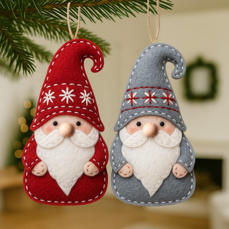 May include: Two felt Christmas gnome ornaments. One is red with white snowflake accents, the other is gray with red snowflake accents. Both have white beards, noses, and stitched details. They hang from twine strings.