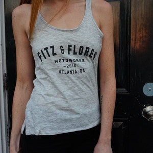 May include: A gray tank top with black text that reads "Fitz & Flores Motoworks - 2016 - Atlanta, GA".