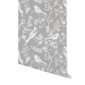 May include: Gray wallpaper with a white floral and bird pattern. The birds are stylized and have long tails. The flowers are small and delicate.