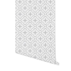 May include: White wallpaper with a repeating grey pattern of stylised flowers in a diamond shape.